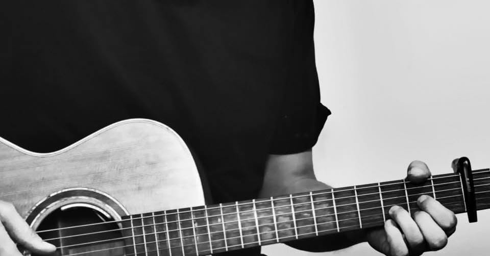 An acoustic guitar resting ready for a beginner guitar lesson
