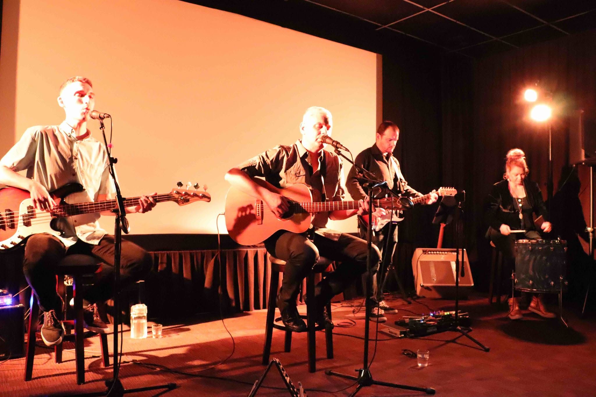 Ryan Edwards performing with a full band under warm orange stage light